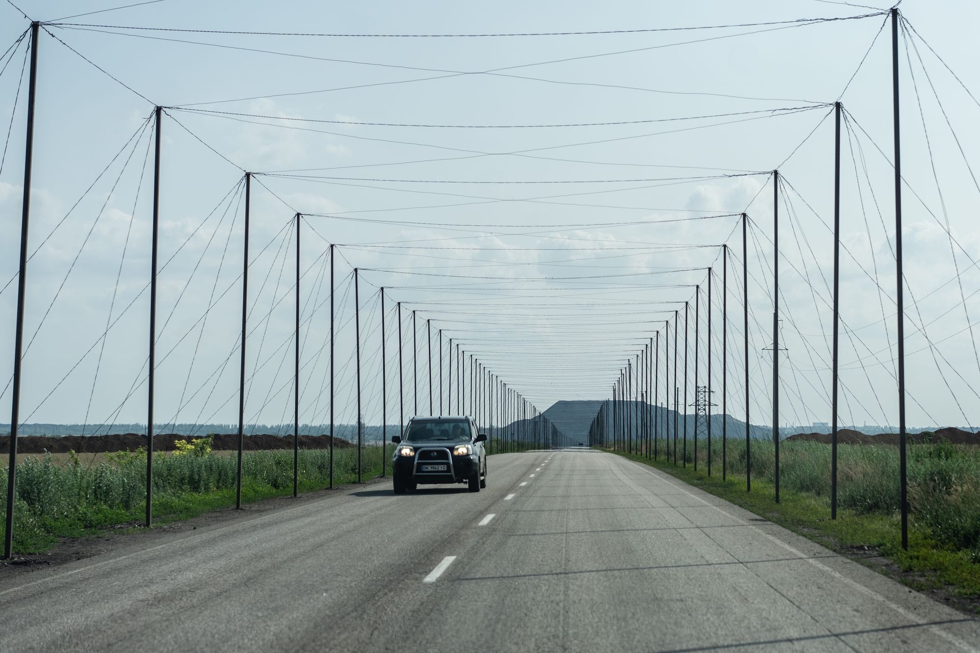 An anti-drone net corridor stretches over the main road leading to the frontline town in Dobropillia, Donetsk Oblast, Ukraine, on June 12, 2025.