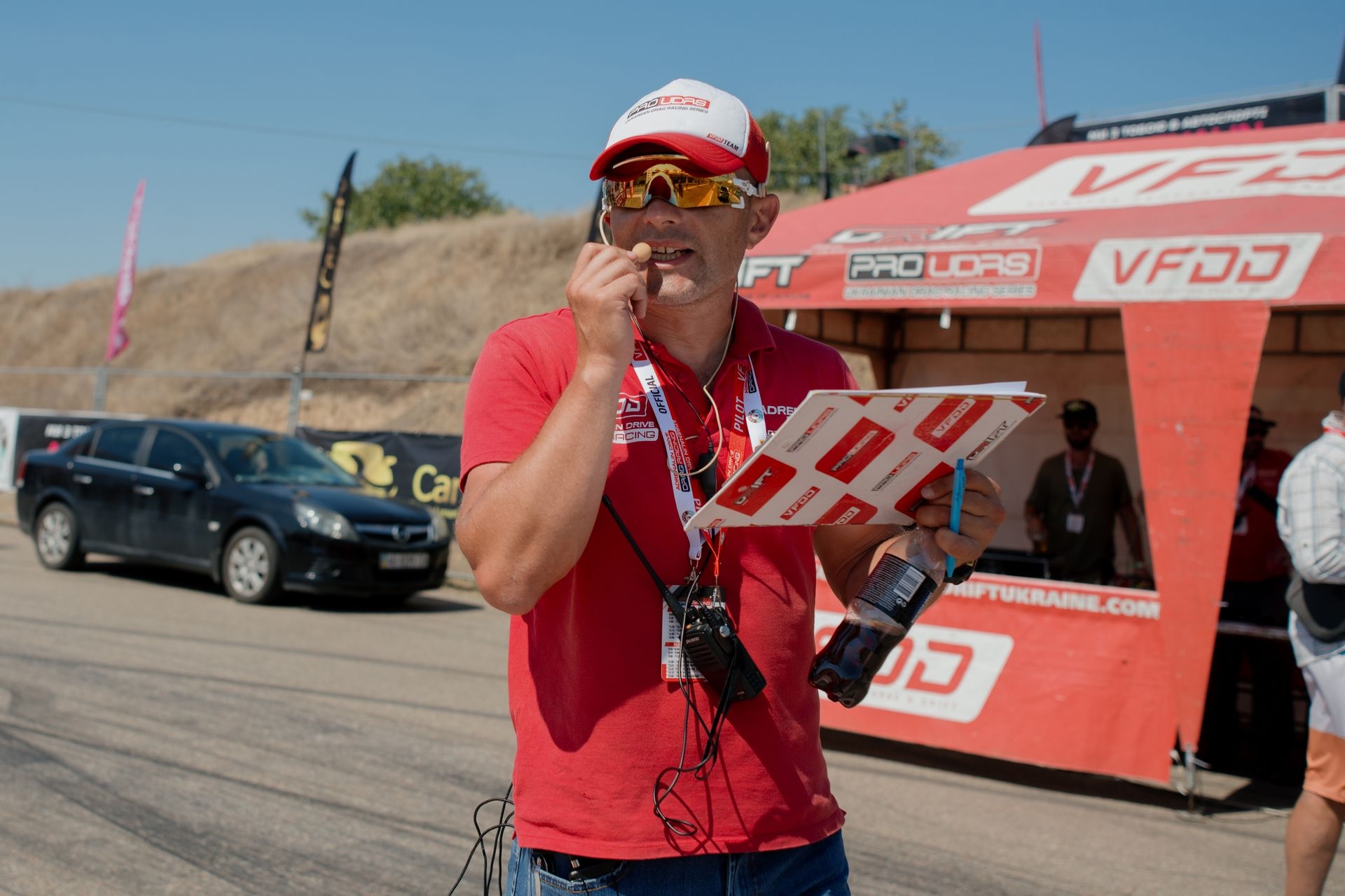 A team member speaks into a mic during a drag racing event in Odesa, Ukraine, on Aug. 10, 2025.